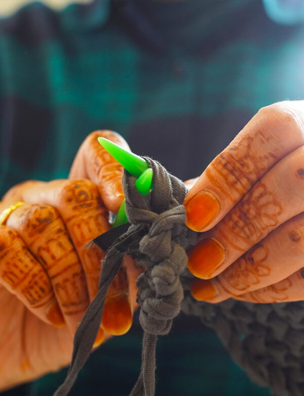 Close up of hands with mendhi patterns knitting